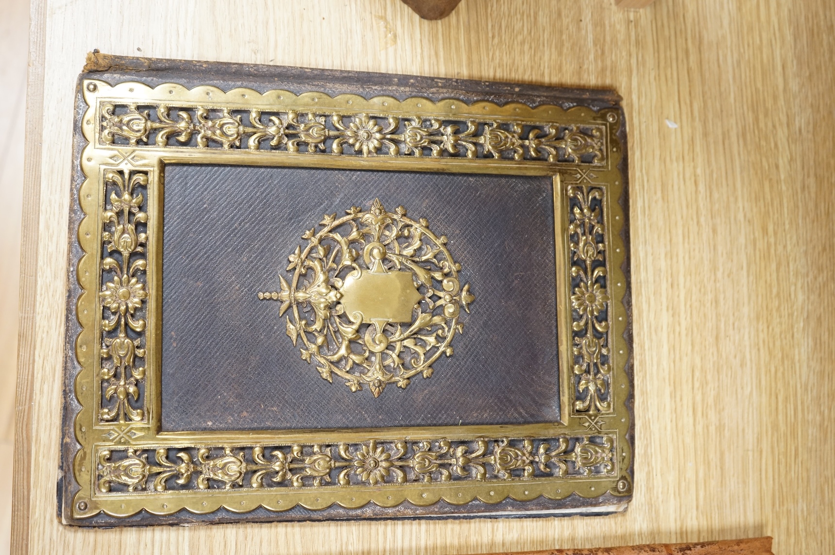 An ornate brass mounted and Morocco leather blotter and a tooled leather blotter of a Persian hunting scene with a red damask lining